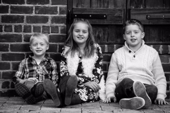 children sitting against wall